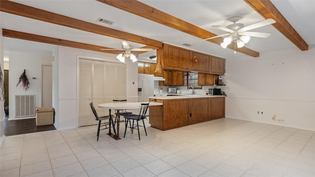 kitchen featuring kitchen peninsula, a kitchen breakfast bar, ceiling fan, sink, and white fridge with ice dispenser