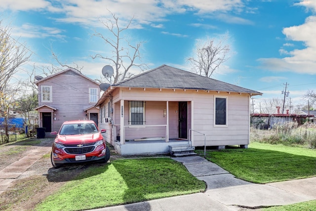 bungalow with a porch and a front lawn