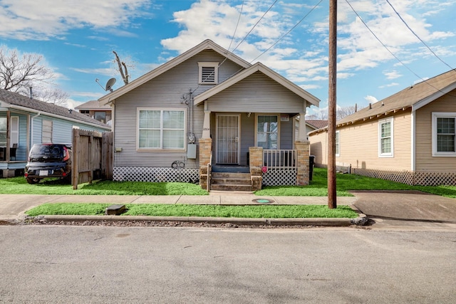 bungalow-style house featuring a porch and a front lawn