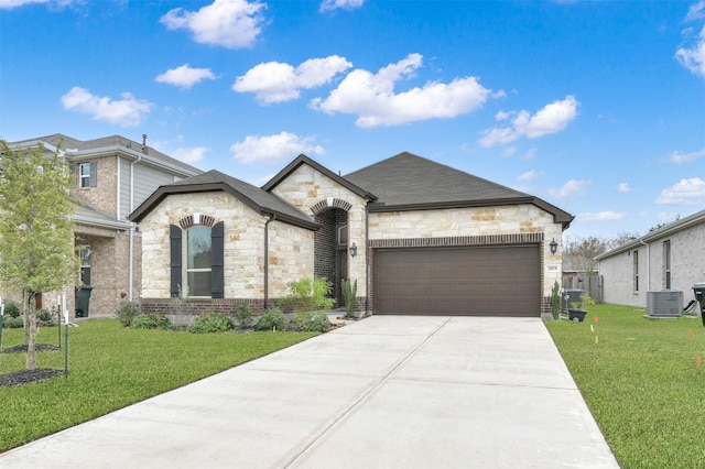 french country style house with cooling unit, a front yard, and a garage