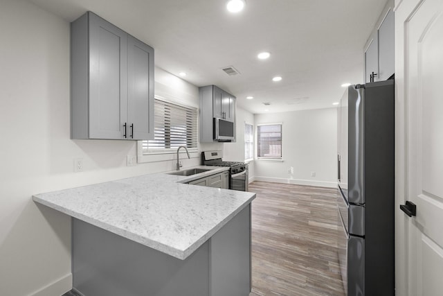 kitchen featuring gray cabinets, sink, kitchen peninsula, and stainless steel appliances