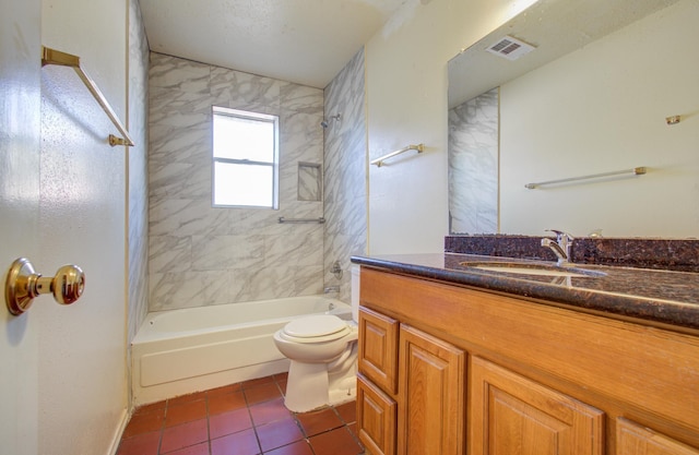 full bathroom with tile patterned flooring, vanity, tiled shower / bath combo, and toilet