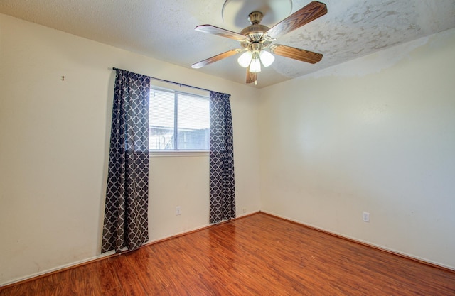 empty room featuring a textured ceiling, hardwood / wood-style flooring, and ceiling fan