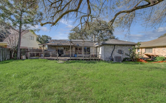 rear view of property featuring a lawn and cooling unit