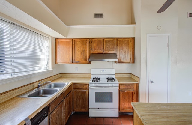 kitchen with gas range gas stove, sink, dishwasher, and dark tile patterned flooring