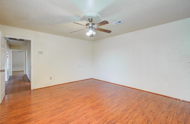 empty room with a textured ceiling, light hardwood / wood-style floors, and ceiling fan