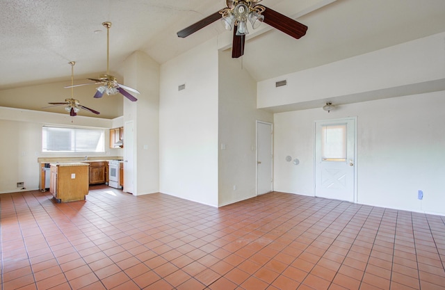 unfurnished living room featuring sink, high vaulted ceiling, light tile patterned flooring, and a textured ceiling