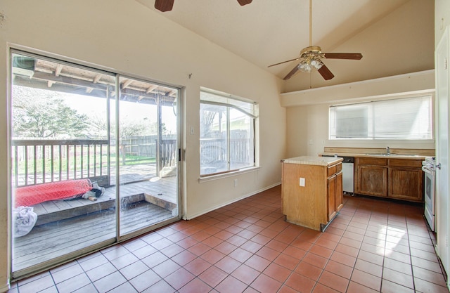 kitchen featuring sink, a kitchen island, vaulted ceiling, electric stove, and light tile patterned floors