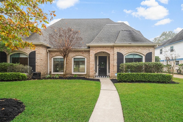 french country style house featuring central AC unit and a front yard