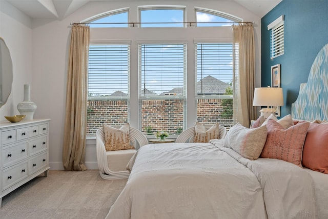 bedroom with light colored carpet and vaulted ceiling