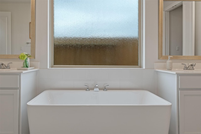 bathroom featuring vanity, a tub to relax in, and a wealth of natural light