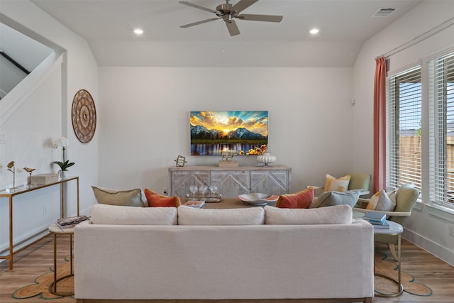 living room with ceiling fan, light hardwood / wood-style flooring, and lofted ceiling