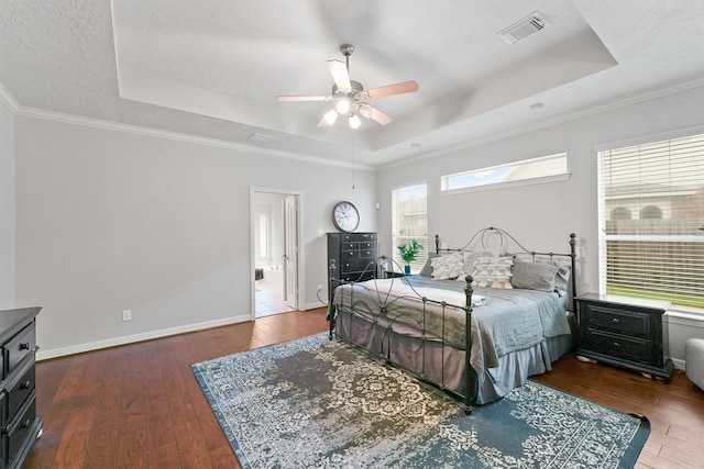 bedroom featuring ceiling fan, dark hardwood / wood-style flooring, and a tray ceiling