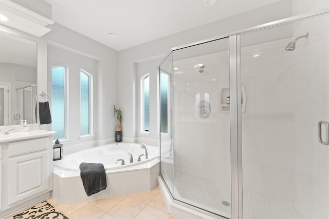 bathroom featuring plus walk in shower, vanity, and tile patterned flooring