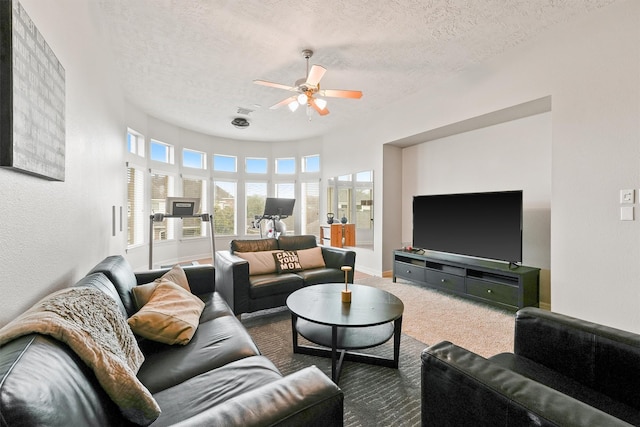 living room with carpet flooring, ceiling fan, and a textured ceiling