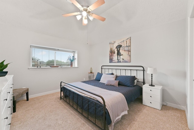 bedroom featuring light carpet, a textured ceiling, and ceiling fan