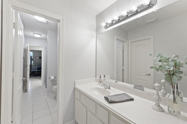 bathroom with tile patterned floors, vanity, toilet, and a textured ceiling