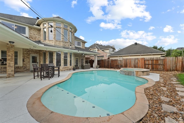 view of pool with an in ground hot tub and a patio