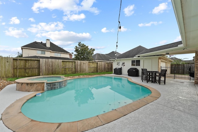 view of swimming pool with an in ground hot tub, a patio area, and a grill