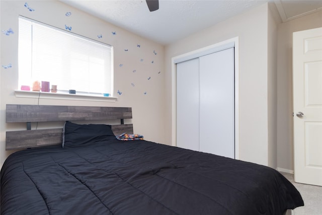 bedroom featuring carpet flooring, ceiling fan, a textured ceiling, and a closet