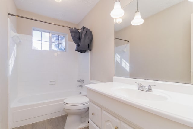 full bathroom featuring vanity, tiled shower / bath, toilet, a textured ceiling, and wood-type flooring