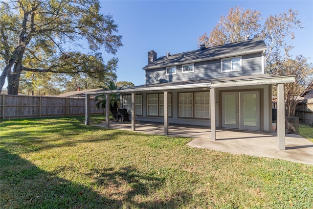 rear view of property with a yard and a patio area