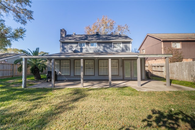 back of house with a patio area and a lawn