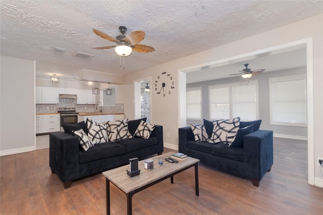 living room featuring ceiling fan, dark hardwood / wood-style flooring, and sink