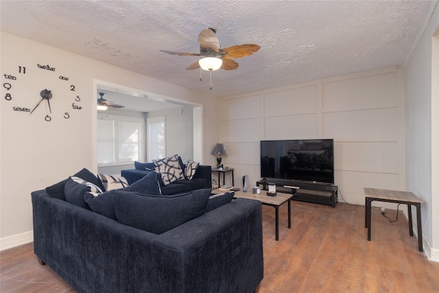 living room with ceiling fan, hardwood / wood-style floors, and a textured ceiling