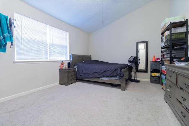 carpeted bedroom with a textured ceiling and vaulted ceiling