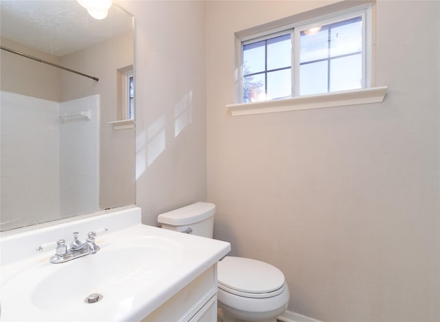 bathroom featuring a shower, vanity, and toilet