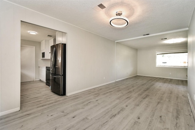 unfurnished living room featuring a textured ceiling and light wood-type flooring