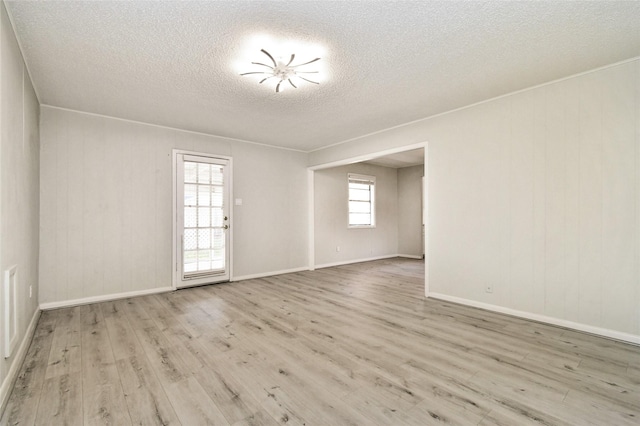 unfurnished room featuring a textured ceiling and light hardwood / wood-style flooring