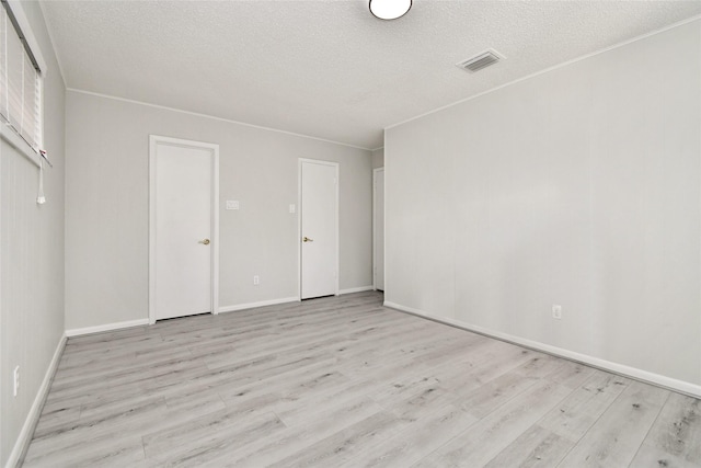 unfurnished room with light hardwood / wood-style floors and a textured ceiling