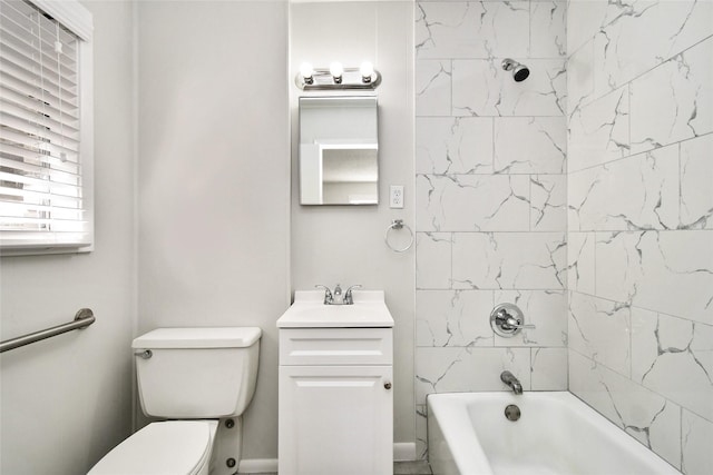 full bathroom featuring vanity, tiled shower / bath combo, and toilet