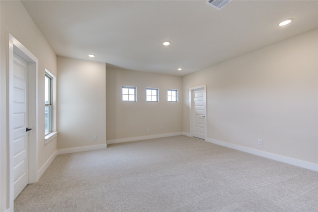 unfurnished room featuring light carpet