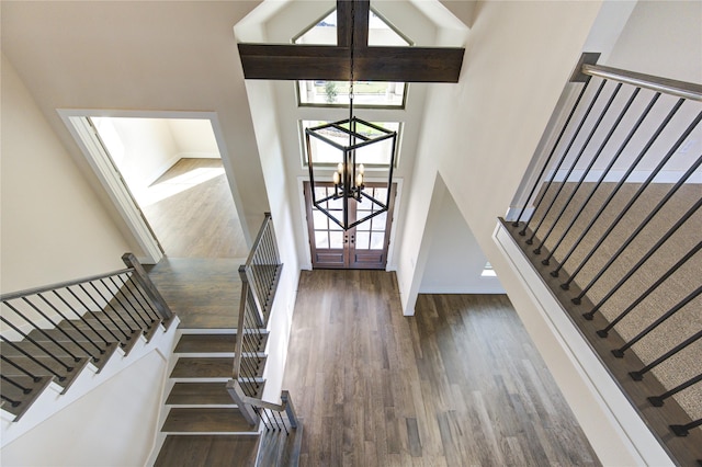 entrance foyer with dark wood-type flooring, a chandelier, and a high ceiling