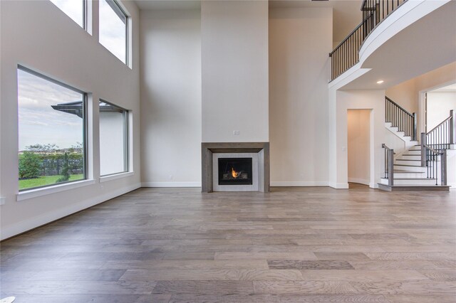 unfurnished living room with hardwood / wood-style flooring and a high ceiling