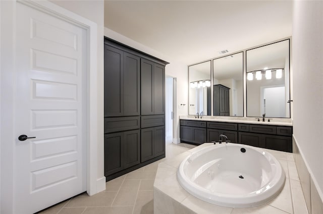 bathroom featuring tile patterned floors, a relaxing tiled tub, and vanity