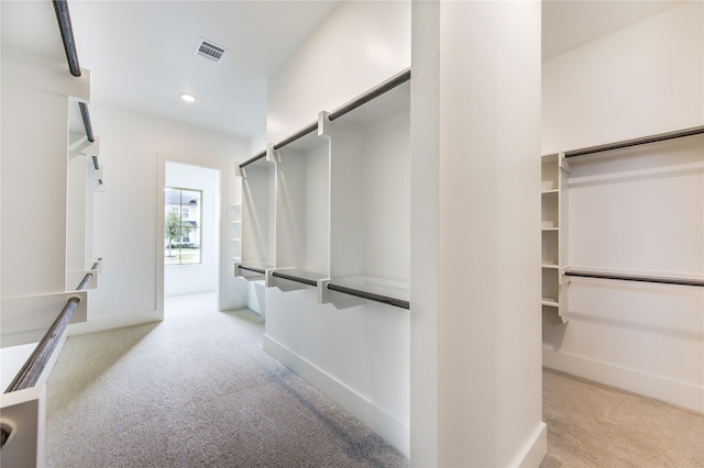 walk in closet featuring light colored carpet