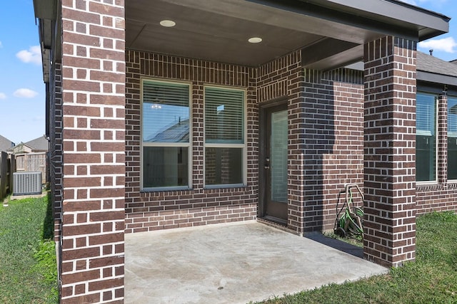 view of exterior entry with cooling unit and a patio area