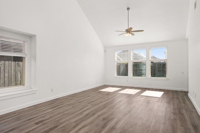 spare room featuring dark hardwood / wood-style floors, ceiling fan, and high vaulted ceiling