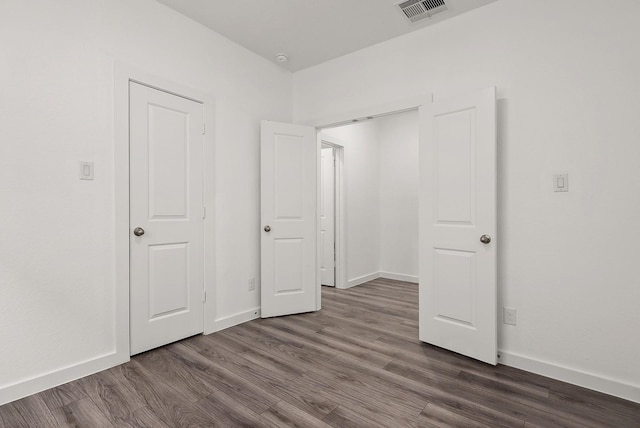 unfurnished bedroom with dark wood-type flooring