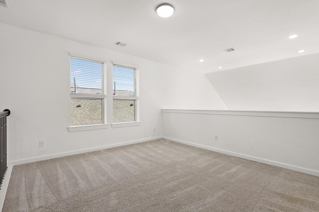 empty room featuring carpet and vaulted ceiling