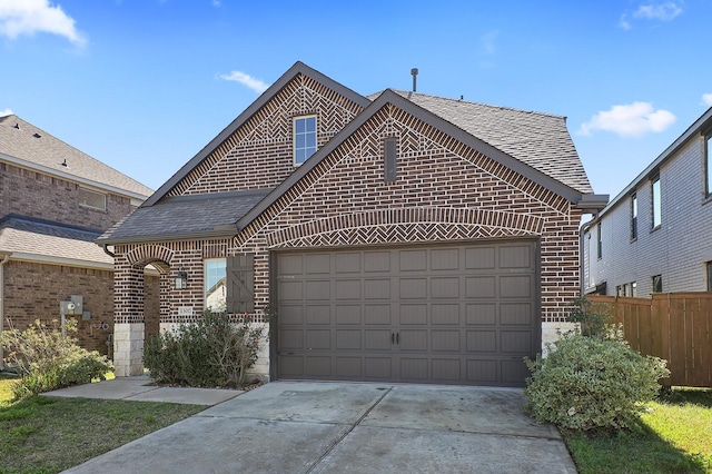 view of front of home with driveway, fence, roof with shingles, an attached garage, and brick siding