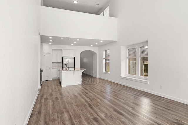 unfurnished living room with hardwood / wood-style flooring and a high ceiling