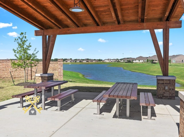 view of patio featuring an outdoor stone fireplace and a water view