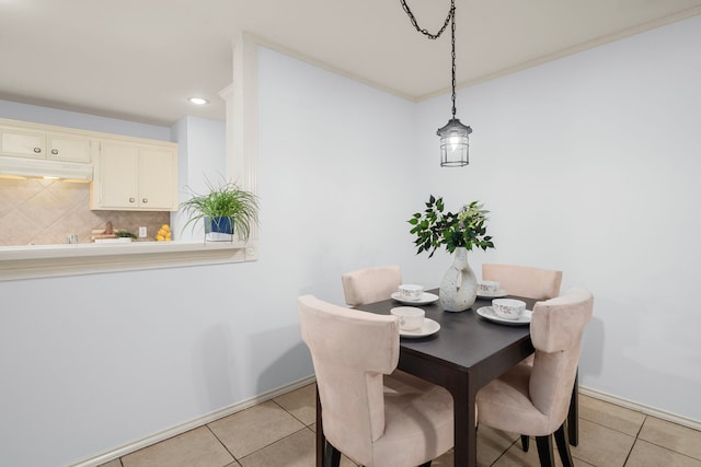 tiled dining room featuring ornamental molding