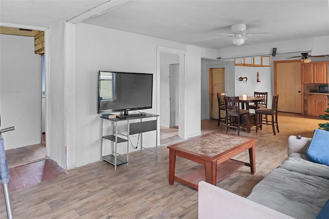 living room featuring ceiling fan and light hardwood / wood-style floors