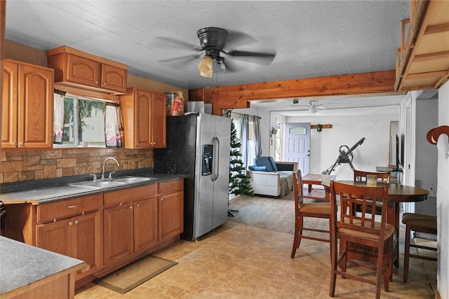 kitchen featuring stainless steel fridge, backsplash, ceiling fan, sink, and beam ceiling